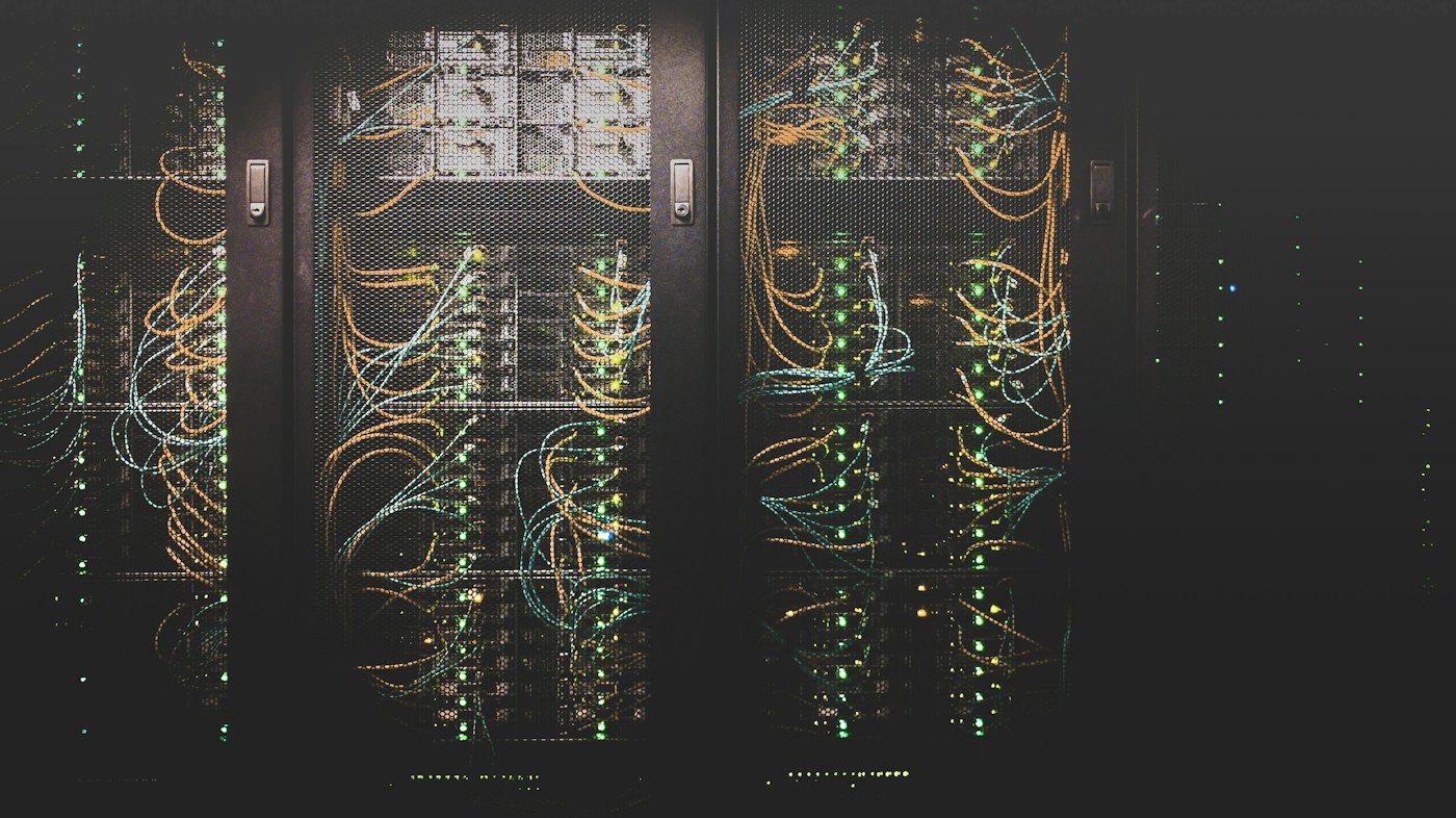 Server racks with glowing lights and amber network cables